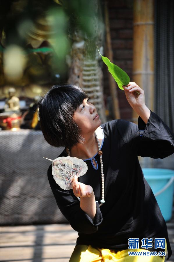 5 июня, в Пекине, художница Ли Юйхань выбирает листье для рисования.