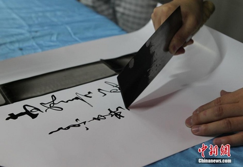 Молодой китайский парень делает каллиграфию ножом