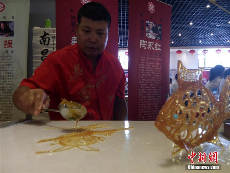 Изготовление сахарных фигурок является традиционным ремеслом нации Хань. На фото: 52-летний носитель этого искусства Гун Баосинь нарисовал героя одного из «Четырех Великих Творений» - "Путешествия на Запад" - Короля Обезьян, солодовым сахаром.