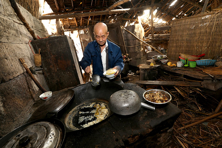 Лян Цзыфу готовит на кухне. Фото/VCG