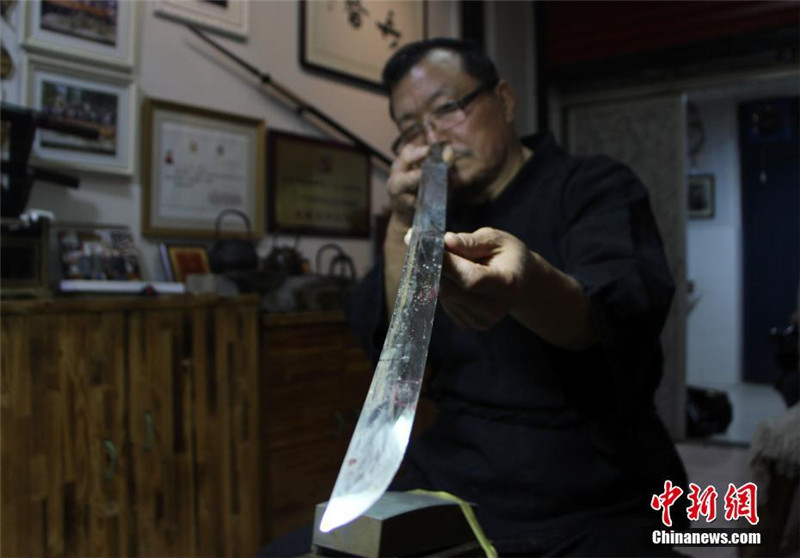 На фото: Янь Минь осматривает восстановленный меч.