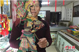 Китайский народный художник вырезает новые фигуры для театра теней
