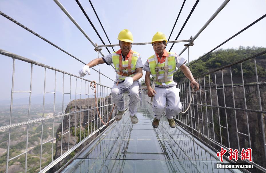 По завершению замены стекол рабочие прыгают на стеклянном мосту, чтобы испытать стекло на прочность и сопротивление арматуры при давлении.