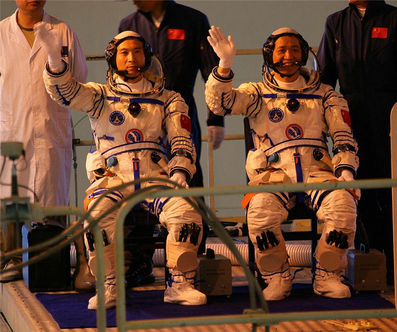 Командир пилотируемого космического корабля "Шэньчжоу-6" Фэй Цзюньлун и пилот Не Хайшэн машут рукой перед полетом в космос