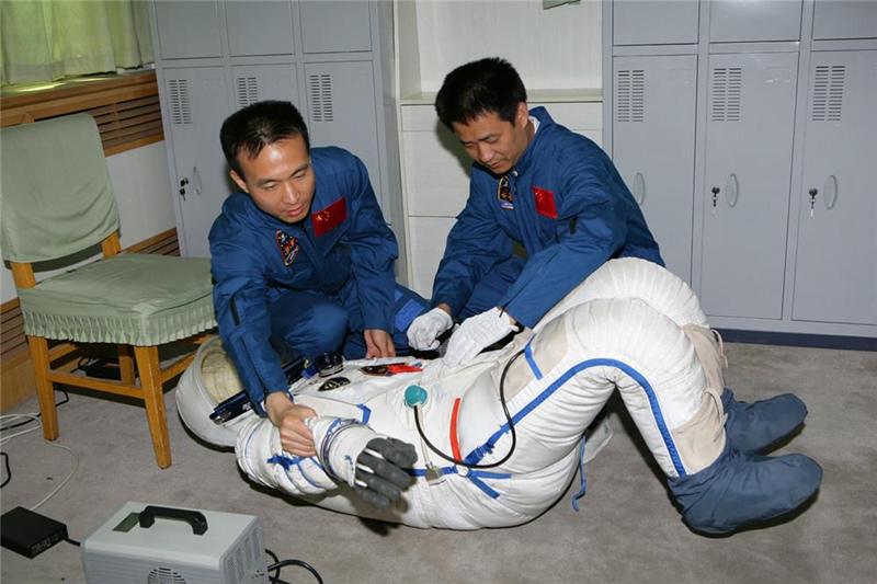 Фэй Цзюньлун и Не Хайшэн проверяют непроницаемость космического скафандра перед тренировкой
