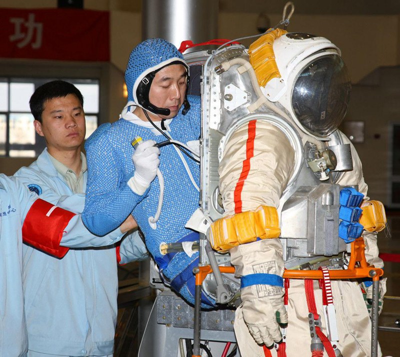 Космонавт Цзин Хайпэн одевает скафандр, специально предназначенный для подводных тренировок и настраивает коммуникационное оборудование.