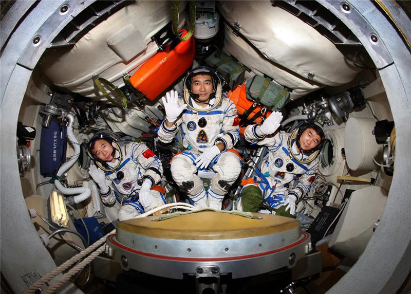 Космонавты Чжай Чжиган (в середине), Лю Бомин (справа) и Цзин Хайпэн(слева) тренируются в посадочном модуле пилотируемого космического корабля "Шэньчжоу-7”.