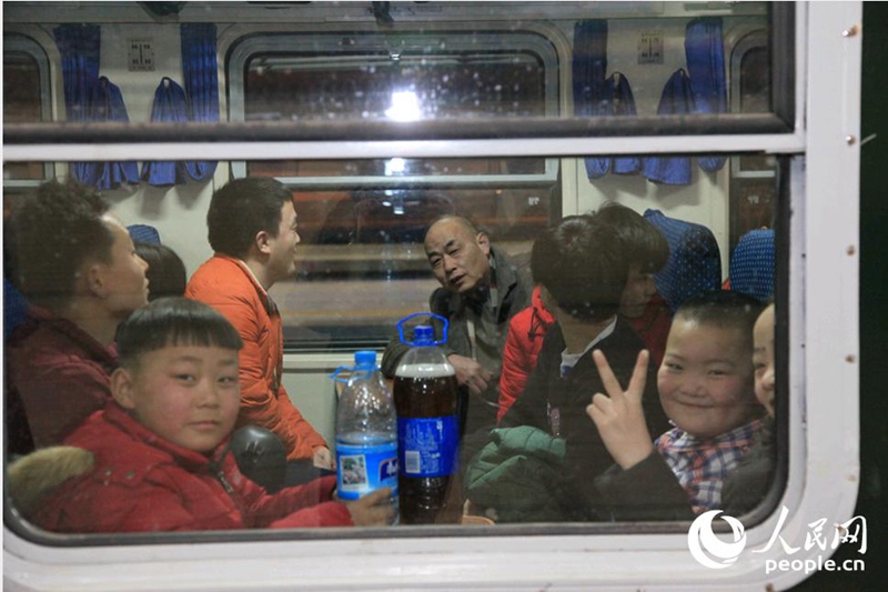 Ранним утром 1 февраля на первом поезде, следующем из Пекина в Чунцин в пик пассажирских перевозок по случаю праздника Весны в этом году, дети смотрят в окно и улыбаются