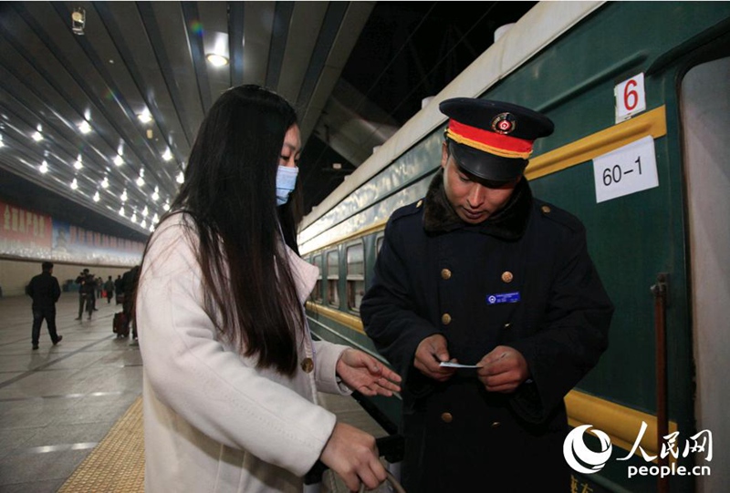 Проводник проверяет билет пассажира при посадке на поезд.