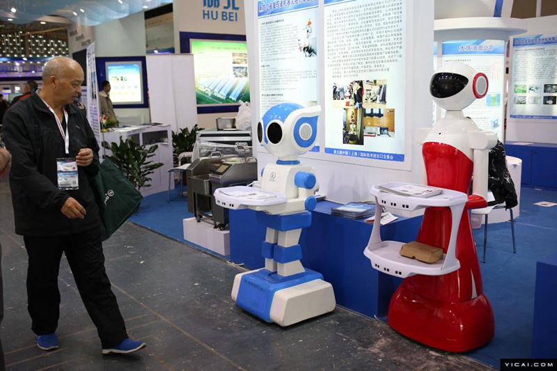 Посетитель Китайской международной выставки по импорту и экспорту технологий в Шанхае рассматривает стенд роботов.Фото: First Finance