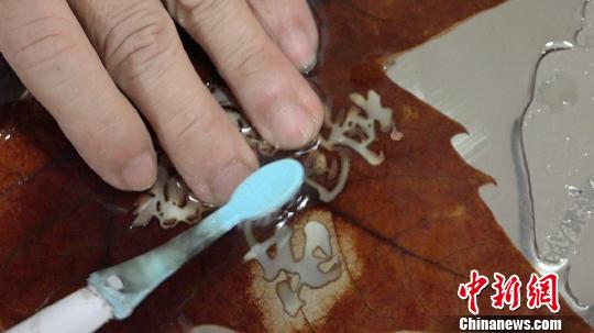 Китаец занимается резьбой по листьям электрической зубной щетки