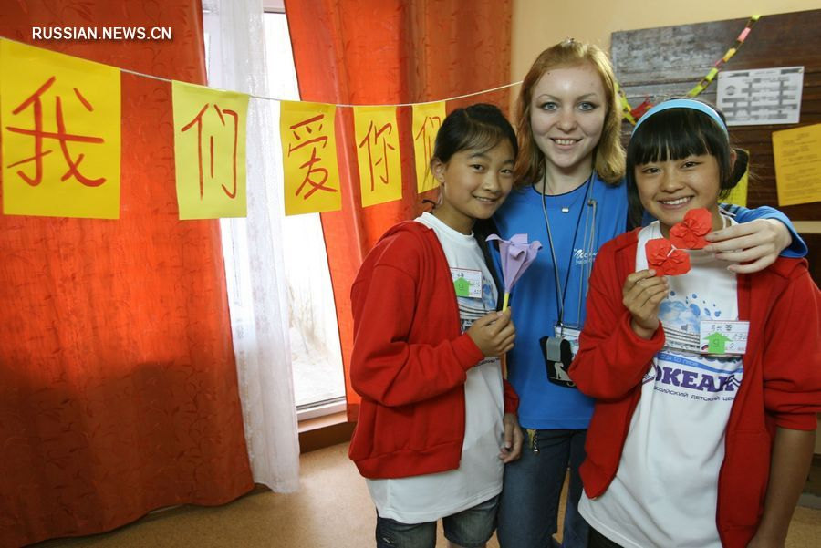 21 июля 2008 года китайские девочки из района, пострадавшего от землетрясения, фотографируются на память со своей российской учительницей во Всероссийском детском центре "Океан" во Владивостоке. /Фото: Синьхуа/
