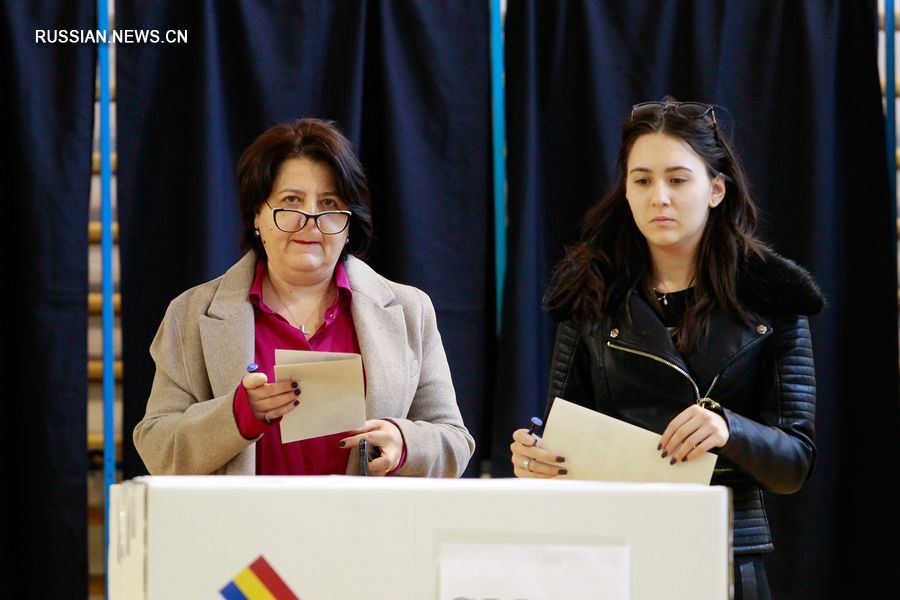 10 ноября две женщины опускают бюллетени на избирательном участке в Бухаресте. /Фото: Синьхуа/