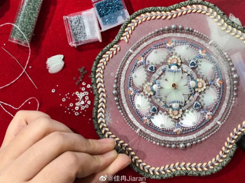 Китаянка изготавливает круглые веера с вышивкой