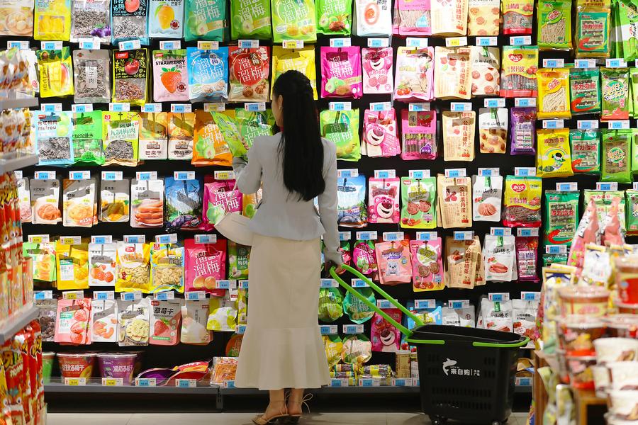11 апреля 2024 года, девушка совершает покупки в одном из супермаркетов города уездного значения Тэнчжоу провинции Шаньдун /Восточный Китай/. /Фото: Синьхуа/