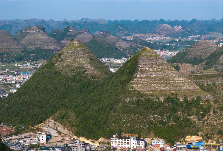 На аэрофотоснимке, сделанном 14 мая 2024 года, запечатлен вид на горы пирамидальной формы в уезде Аньлун провинции Гуйчжоу на юго-западе Китая. Несколько гор, напоминающих египетские пирамиды, в пригороде уезда Аньлун в последнее время стали популярной туристической достопримечательностью. /Фото: Синьхуа/