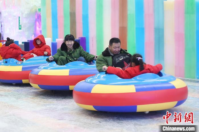 Туристы наслаждаются прохладой в крытом ледяном и снежном комплексе в городе Хуайань