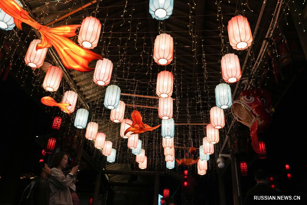 Жители и туристы наслаждаются фонарями во время каникул по случаю праздника Весны в Китае